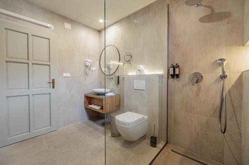 a bathroom with a toilet and a glass shower at Bohém Borklub in Tállya