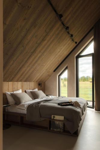 a bedroom with a large bed with a large window at Baniska Houses Mountain View DOM Z WIDOKIEM NA TATRY JACUZZI ORAZ SAUNA W CENIE in Szaflary