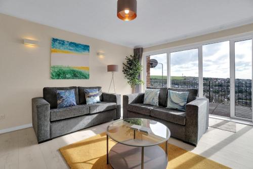 a living room with two couches and a table at Oceanview Retreat & Private Parking in Saltdean