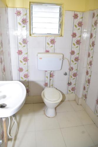 a bathroom with a toilet and a sink at Hotel Srikrishna International in Tarapith