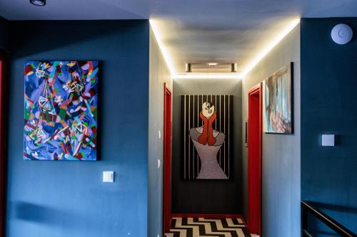 a hallway with two paintings of a woman on the wall at Bohém Borklub in Tállya