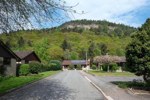 an empty street with a mountain in the background at Greenwood - Stunning Scandinavian Style Home in the heart of Ballater Royal Deeside in Ballater