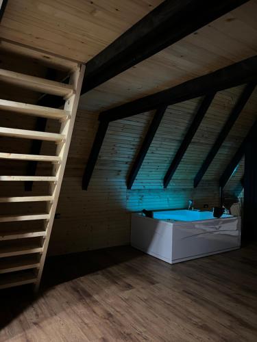 a attic room with a hot tub and a ladder at Vila INNA in Dubrave Gornje