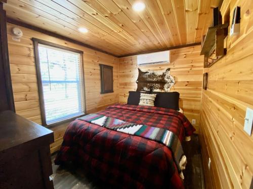 a bedroom with a bed in a wooden cabin at Resort at Fredericksburg Unit 2 in Rocky Hill