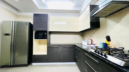 a kitchen with a stainless steel refrigerator and a stove at Olive Service Apartments - Green Park in New Delhi
