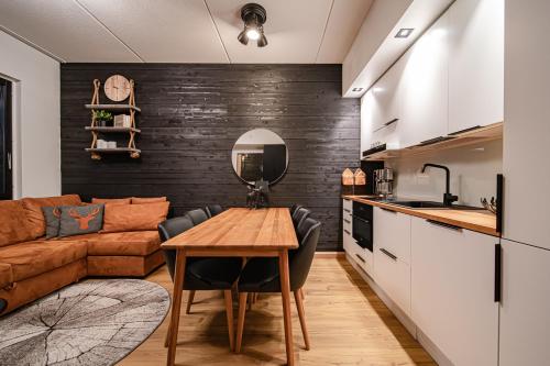 a kitchen and living room with a table and a couch at Ski Chalet C9 Ski-in Ski-out by Aavalevi in Levi