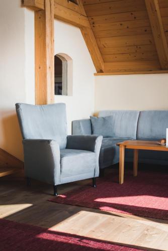 a living room with a blue couch and a table at Hotel Saziani in Straden