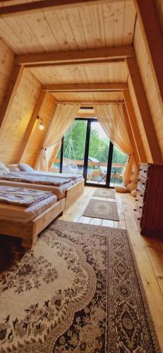 a room with three beds and a rug at Cabana Aframe Blidari in Blidari