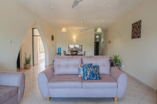 a living room with a couch and a table at 2-BR House Diani Beach - 3 Min to Beach in Galu