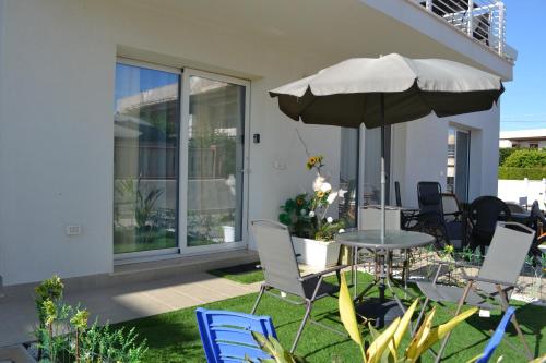 a patio with a table and an umbrella and chairs at Prima Fila in Calabernardo