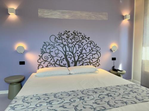 a bedroom with a white bed with a tree headboard at Hotel Europa Varese in Varese