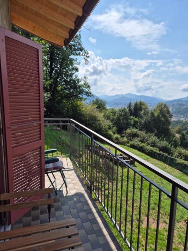 a porch with a bench and a view of the mountains at Casa Nogo in Cadro