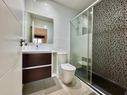 a bathroom with a toilet and a glass shower at Lucerna II, Bajo 2 in Dehesa de Campoamor