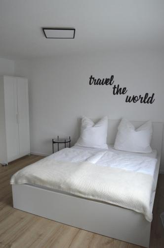 a bedroom with a bed with the words travel the world at A2Apartment - 1-Zimmer-Apartment nähe Playmobil in Oberasbach