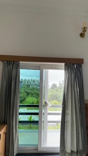 a window with a view of a balcony at Sonam hotel and restaurant in Kushālnagar