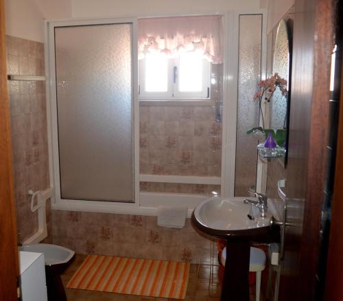 baño con lavabo y aseo y ventana en Holidays 71, en Nazaré