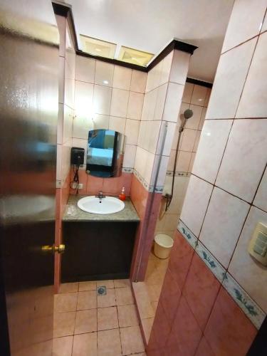 a bathroom with a sink and a shower at Amax Inn Makati in Manila