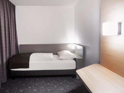 a small bedroom with a bed and a window at B&B Hotel Dessau in Dessau