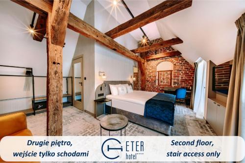 a bedroom with a bed and a brick wall at Hotel ETER in Toruń