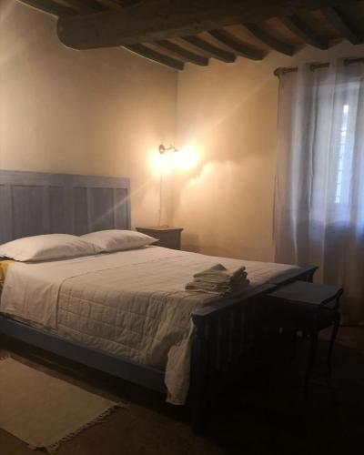 a bedroom with a bed and a light and a window at Affittacamere Serenità in Umbertide