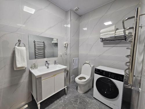 Un baño con inodoro y lavadora. en Bobs apartments, en Samarkand