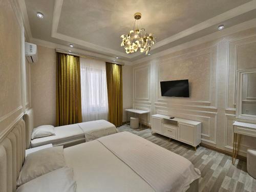 Una habitación de hotel con dos camas y un televisor. en Bobs apartments, en Samarkand