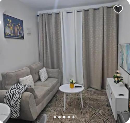 a living room with a couch and a table at golden home in Nairobi