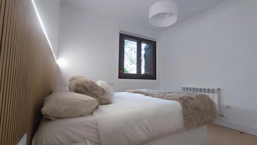 Un dormitorio con una cama con dos almohadas encima. en El Llano Descanso, en Escarrilla