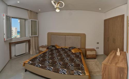 a bedroom with a large bed in a room at Résidence Costa in Chott Meriem