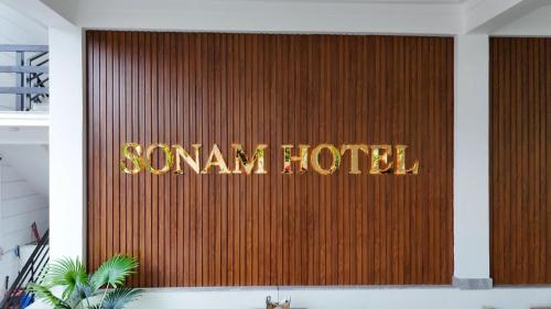 a sign that reads samurai hotel on a wooden wall at Sonam hotel and restaurant in Kushālnagar