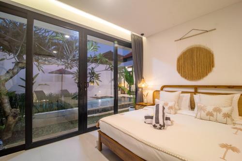 a bedroom with a bed and a view of a pool at Villa CanSavina - 3 Rooms - Center Of Seminyak in Seminyak