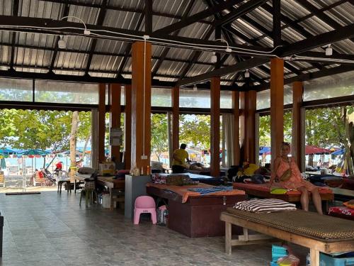 a woman sitting on a bench in a market at Title Halo Andaman Coast Pool View Gym in Nai Yang Beach