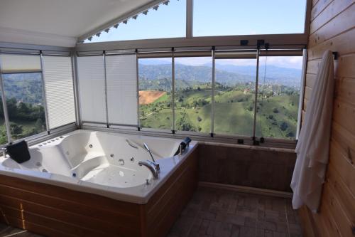 a bath tub in a room with a large window at Kartal Gözü Dağ Evi in Ardeşen