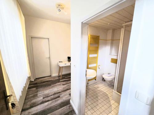 a bathroom with a toilet and a sink at City Center Hotel Garni Cuxhaven in Cuxhaven