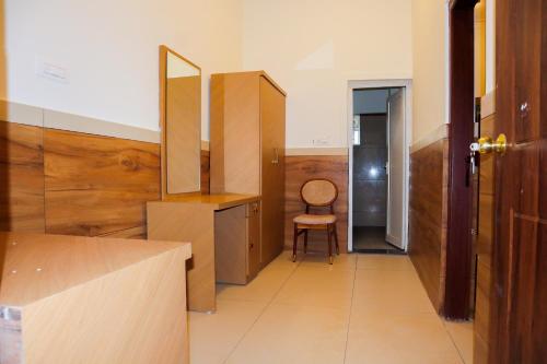 a bathroom with a vanity and a chair in a room at Sonam hotel and restaurant in Kushālnagar