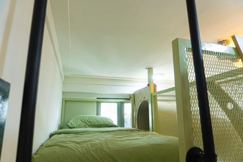 a small bed in a room with a ladder at Cyberjaya HOMEstay With Playground Slide - 5 Pax in Gua Sai