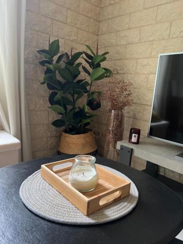une table avec une bougie dans un bocal en verre sur un plateau dans l'établissement Jolie maison de village proche de la mer, à Sainte-Marie-la-Mer