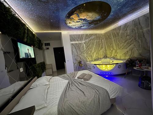 a bedroom with a large bed and a bath tub at R U B I room by 50 shades in Baia Mare