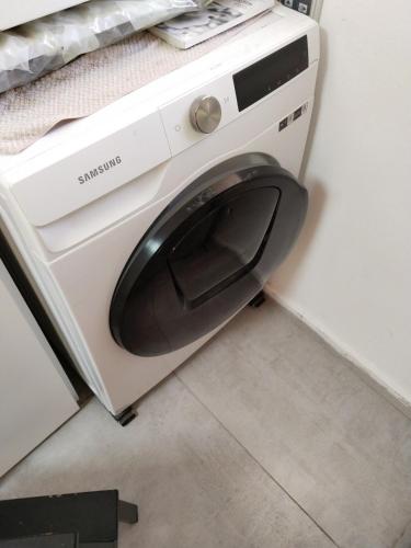 a washing machine with its door open in a bathroom at Rony's Place in Ramat Gan
