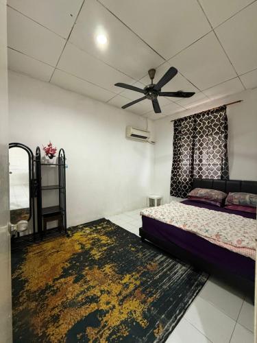 Un dormitorio con una cama y un ventilador de techo. en Homestay D'Putra Bertam - Homestay Kolam Bajet, en Kepala Batas