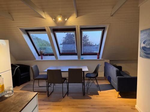 a room with a table and chairs and windows at The Sunflower - Huge 240m2 7-bedroom house for 16 people - Free parking - 15 beds, 2 kitchen & 3 bathrooms in Munkebo