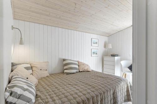 a bedroom with a bed and a white wall at TV1517-Albaek-Jasonvej-1 in Horsnab