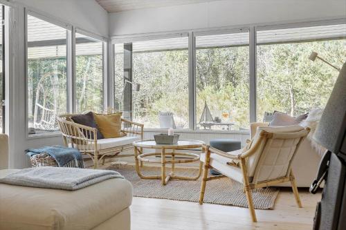 a living room with chairs and a table and windows at TV1517-Albaek-Jasonvej-1 in Horsnab