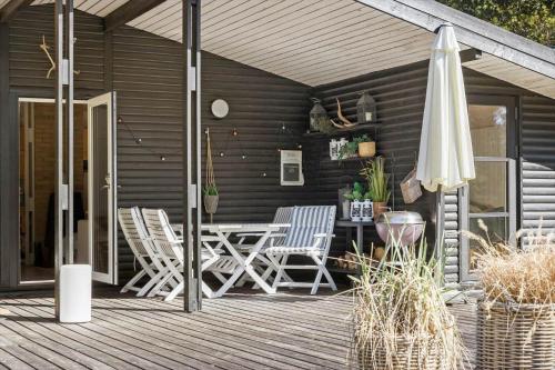 a patio with a table and chairs and an umbrella at TV1517-Albaek-Jasonvej-1 in Horsnab