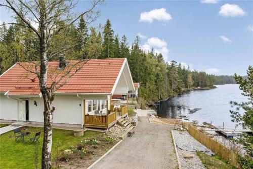 a house with a red roof next to a river at BOH128-Uddevalla-Baeve-Mallsjoen-237 in Sörvik