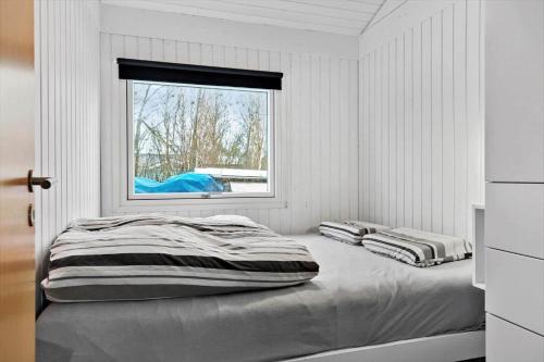 a white room with two beds and a window at TV1567-Bindslev-Svingelvej-9 in Tversted