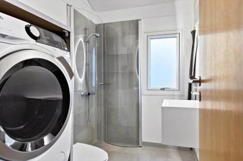 a washing machine in a bathroom with a shower at TV1567-Bindslev-Svingelvej-9 in Tversted