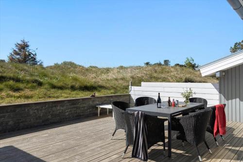 a patio with a table and chairs on a deck at TV1567-Bindslev-Svingelvej-9 in Tversted
