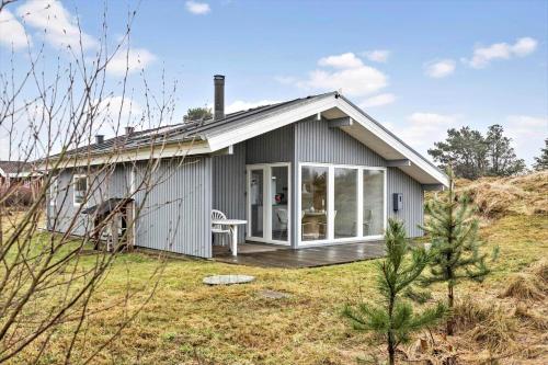 a small grey house with a porch and a deck at TV1567-Bindslev-Svingelvej-9 in Tversted