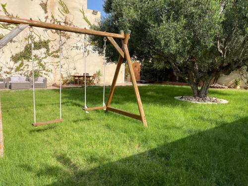 an empty swing set in a yard with a tree at La Villa Bleue Djerba Houmt Souk in Houmt Souk